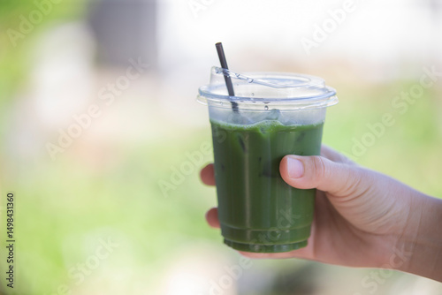 hand holding a glass of green tea