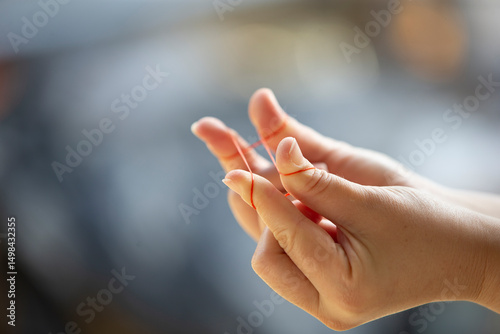 A woman's hands playing with a rubber band