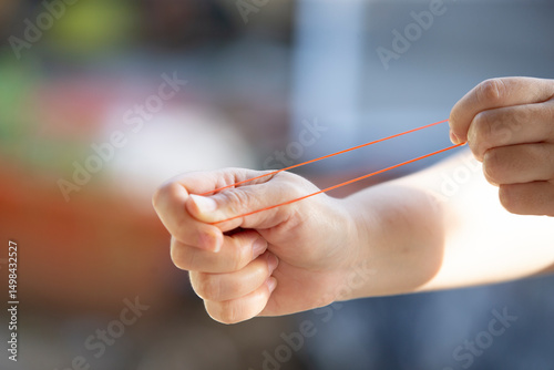 A woman's hands playing with a rubber band