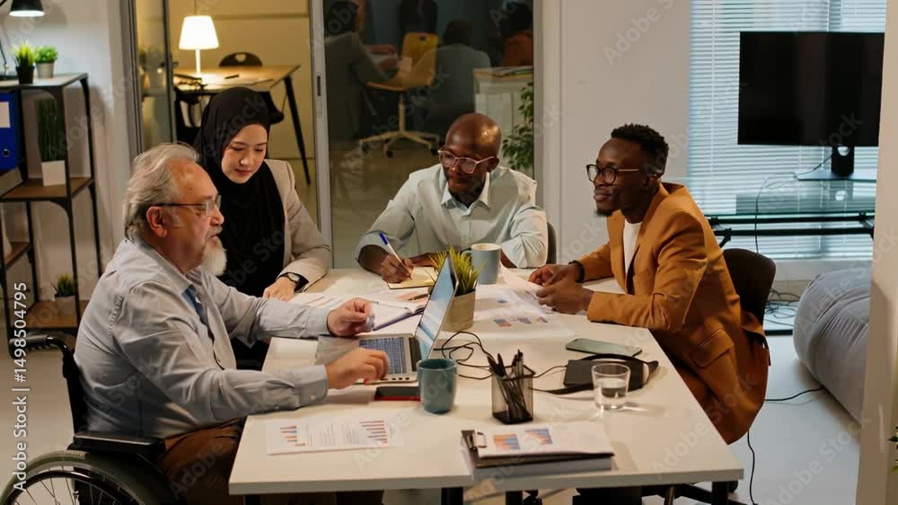 Intergenerational team of multicultural business coworkers working on project during productive session in modern warm office setting