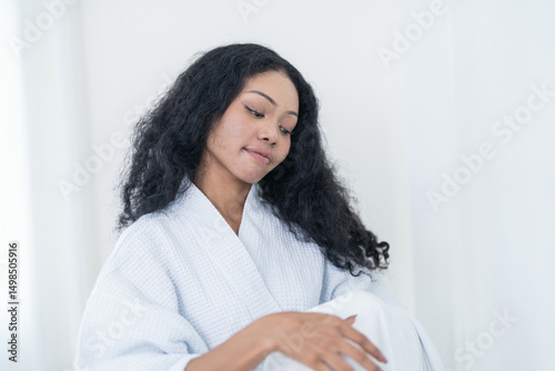 Free Download Confident woman in bathrobe smiling brightly against a white background, embracing natural beauty and self care. - GFXLoad