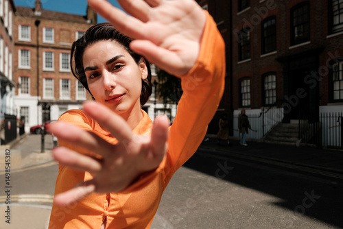 Young woman gesturing with hands in urban setting