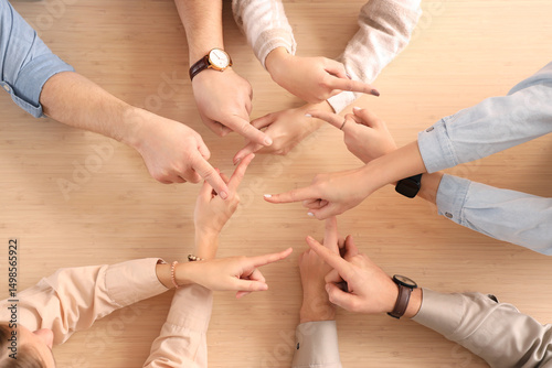 Fotografie Group of people pointing at each other on table, top view
