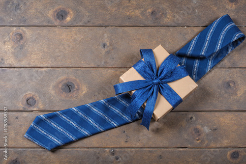 blue tie and a gift box on a wooden table