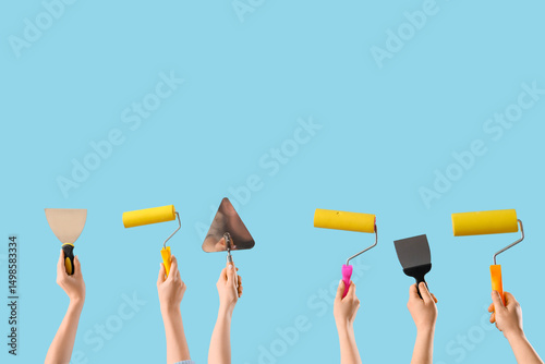 Many hands with paint rolle...