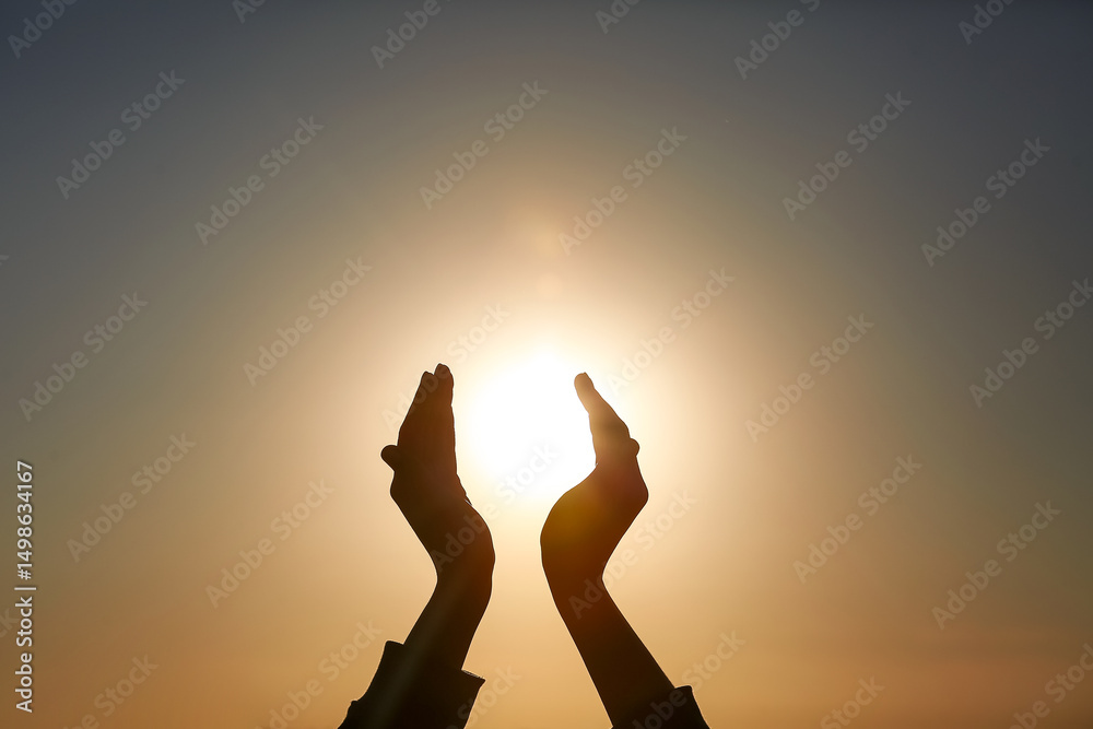 Fototapeta premium Silhouette of female hands holding sun at sunset. Summer solstice