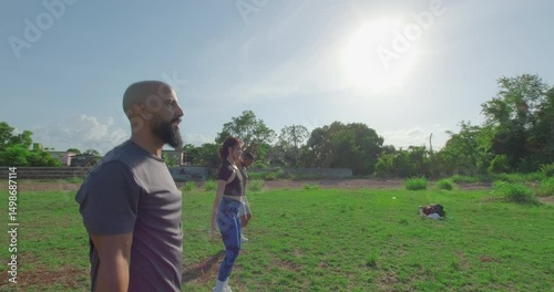 Group of people performing jumping jacks in slow motion in a park. Outdoor exercises