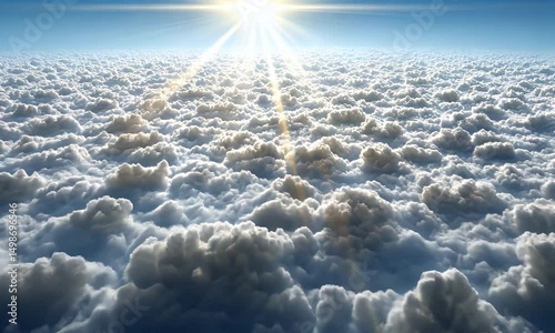 A majestic vista of clouds stretches towards the horizon under a bright sun. Rays of light pierce through the ethereal, fluffy formations. The sky is a beautiful gradient
