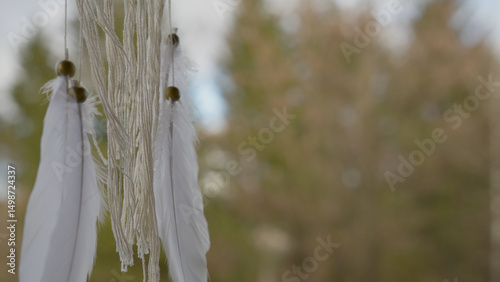 A dream catcher on a with a blurred nature background.