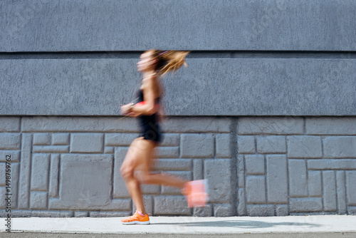 Young woman jogging outdoors, motion concept