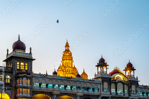 Mysore Palace in Karnataka, India, with a bird flying in the evening sky photo