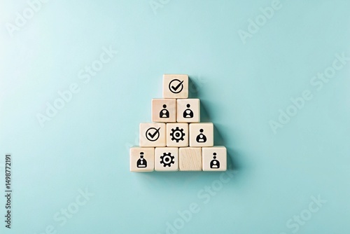 A pyramid structure made of wooden blocks, each containing different icons. The top block has a checkmark, while the lower blocks have various symbols related to processes or tasks