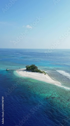 Aerial view of remote island with small house and jetty in Indian Ocean.Paradise location.Vertical video