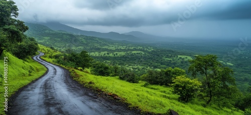Scenic winding road through lush green hills under dramatic cloudy sky