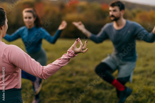 Obraz na plátne Group of athletes practicing yoga in nature at sunset, focusing on mindfulness