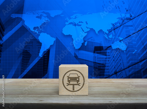 Fototapeta Naklejka Na Ścianę i Meble -  Service fix car with wrench tool icon on wood block cube on wooden table over world map, office city tower and skyscraper, Business repair car service concept, Elements of this image furnished by NASA