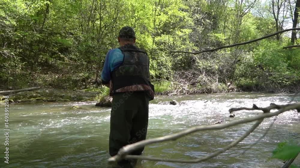 Man fishing in the tranquil waters of Crni Timok Serbia surrounded by lush greenery during a sunny day Man fishing in the tranquil waters of Crni Timok Serbia surrounded by lush greenery during a sunny day