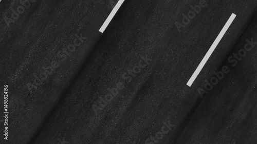 Bird’s-eye drone view highlights the engineering precision behind a straight asphalt road, showcasing quality infrastructure and modern construction techniques.
