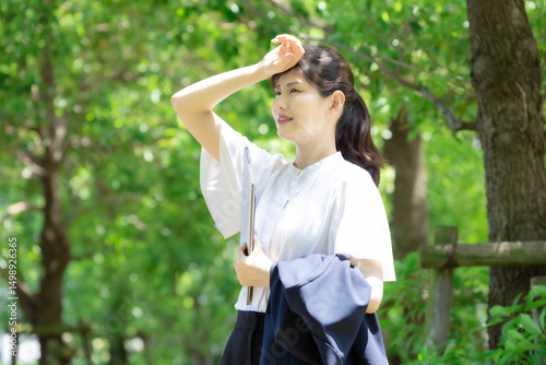 夏の暑い日に仕事で屋外にいる女性