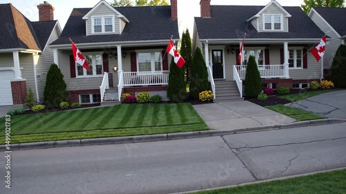 Canadian suburban homes with manicured lawns and national flags lining a quiet street

