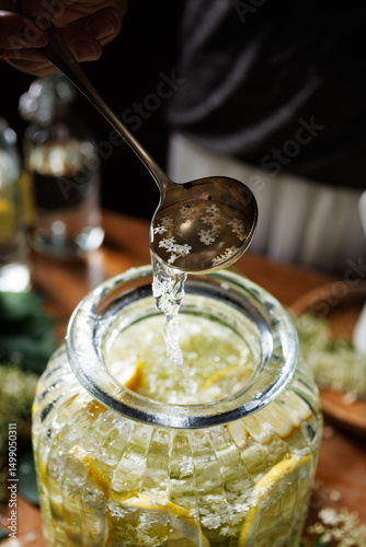 Close up of preparation of elderberry flower syrup, soft light with deep shadows.