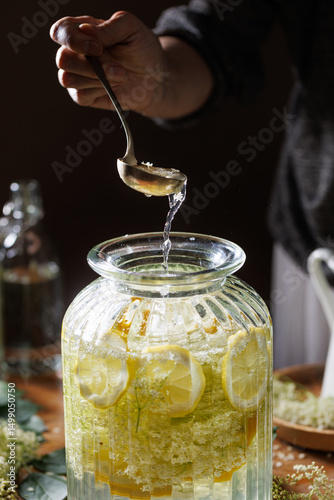 Close up of preparation of elderberry flower syrup,  soft light with deep shadows.