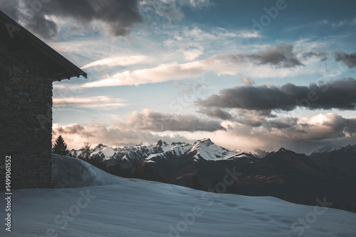 sunset over the mountains with hut foreground in backlight