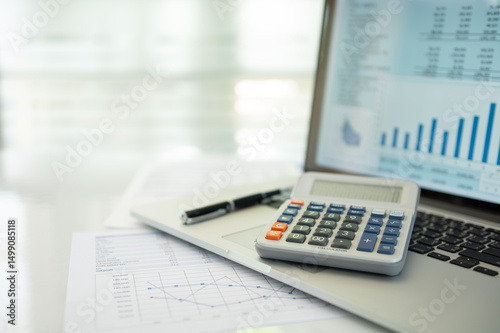 calculator, account statement and business report with financial budget portfolio show on screen laptop computer. accounting business concept.