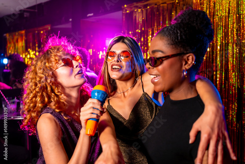 Obraz na plátně Happy multi ethnic friends singing karaoke in nightclub