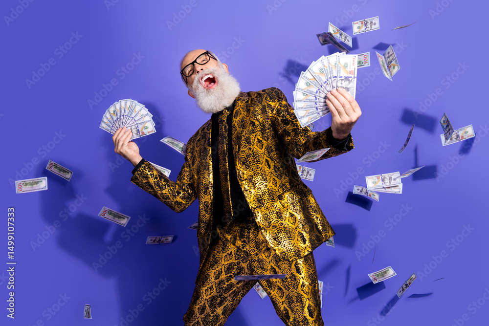 Fototapeta premium Eccentric elderly gentleman in golden suit celebrating with cash on vibrant purple background