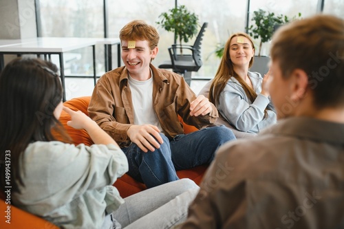 Friends playing guessing game with sticky notes on foreheads