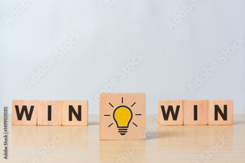 Cube, dice or blocks with message win-win with yellow light bulb on wooden background