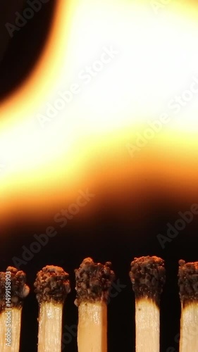 The flame lights up smoothly along a row of matches on a black background on a black background. brightly burning matches burn smoothly and go out on a black background. Close-up. asmr