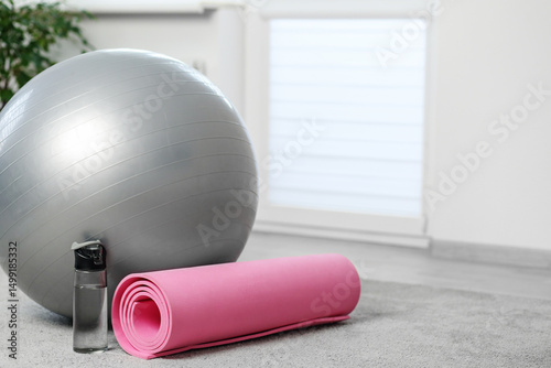 Home workout setup with yoga mat and fitness ball. Copy space.