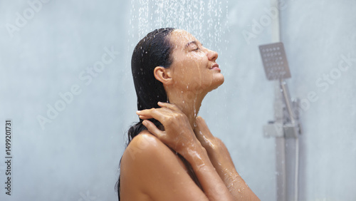 Фотография Woman Relaxes Under Soothing Shower with Eyes Closed