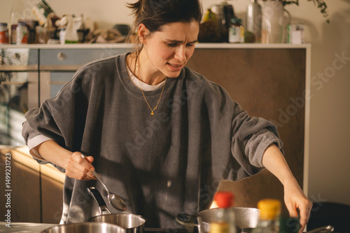 Εκτύπωση καμβά Young housewife having a calamity in the kitchen reacting in shock, she cooks dinner