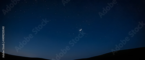 A deep navy blue night sky sprinkled with tiny, glowing stars, with a faint crescent moon glowing softly in one corner.