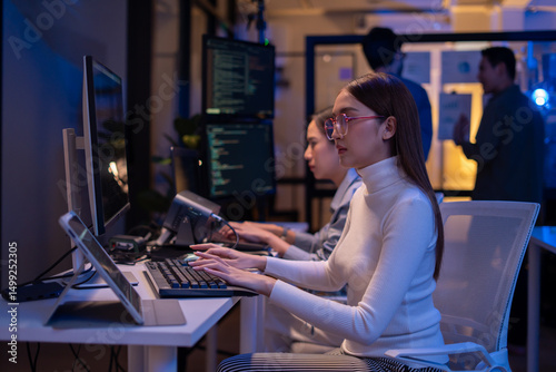 Fototapeta kuchenna Asian software engineer or programmer team working late in development office,problem solving or algorithm of ai assistant helping for work.software developer,digital technology security concept