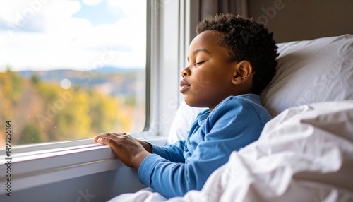 Serene Contemplation: A young child sits by a window, eyes closed in peaceful meditation, his face illuminated by soft, natural light, creating a moment of quiet reflection.