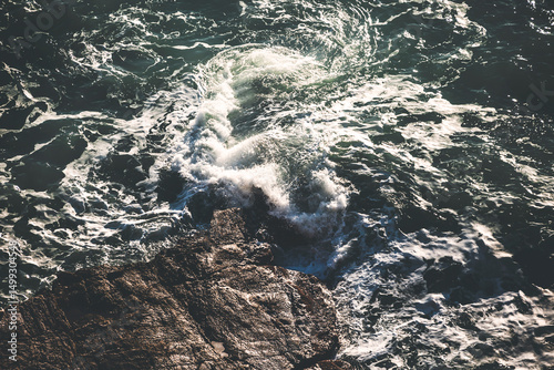 Fototapeta Naklejka Na Ścianę i Meble -  sea waves crashing on the rocks at golden hour