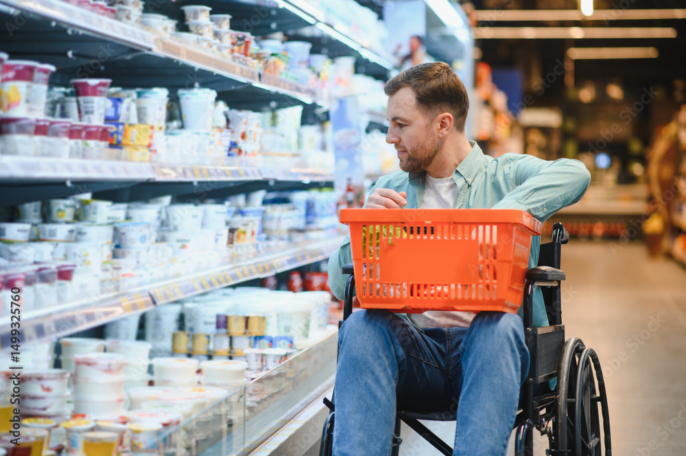 Obraz premium Customer using wheelchair choosing groceries in supermarket dairy section