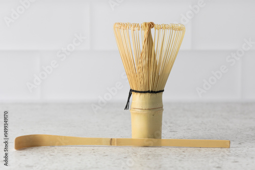 Bamboo whisk and scoop resting on white kitchen counter for matcha preparation