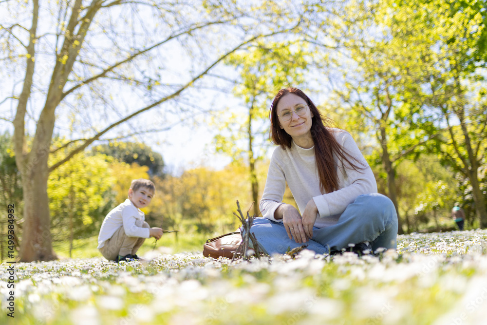 Mother and son enjoying a sunny spring day in a field of daisies Mother and son enjoying a sunny spring day in a field of daisies