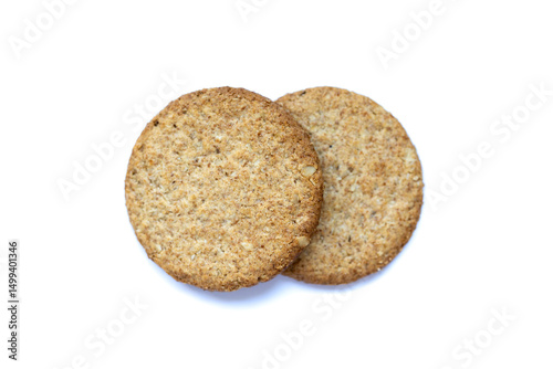 Two round oat cookies with visible grains on white background. Wholesome snack perfect for healthy diet, natural lifestyle, and soft focus food photography.
