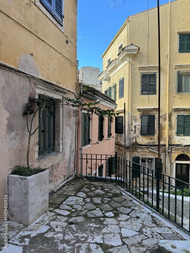 Fototapeta Naklejka Na Ścianę i Meble -  Golden hour view of Corfu Town (Kerkyra) on the island of Corfu, Greece. Warm sunlight bathes the historic buildings, narrow streets, and coastal architecture, highlighting the charm of this Mediterra