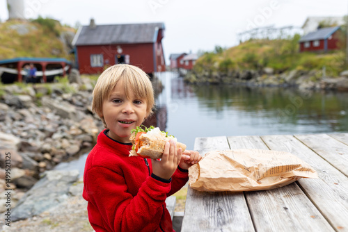Obraz na plátně Cute little child, enjoying the view in small A village on the end of Lofoten, N