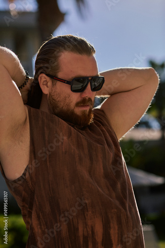 Man holding his hair in the sunlight