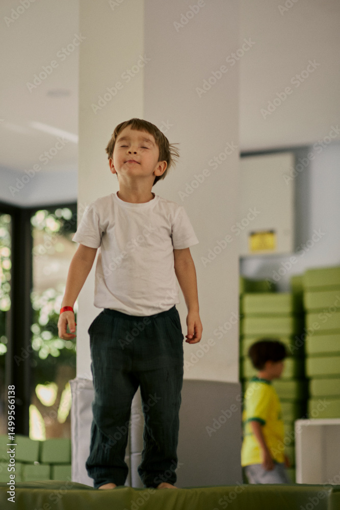 Fototapeta premium Little boy plating in the indoor kids club.