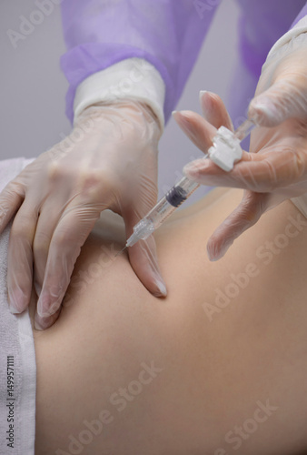 Physiotherapist doing an injection to the back of a patient