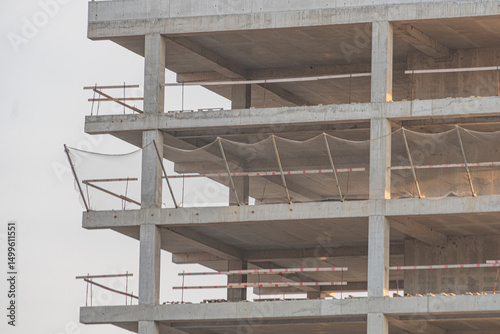 Image of an unfinished building under construction, showing concrete pillars, beams, and rebar The structure could be for a commercial or residential project yet to be completed No windows installe